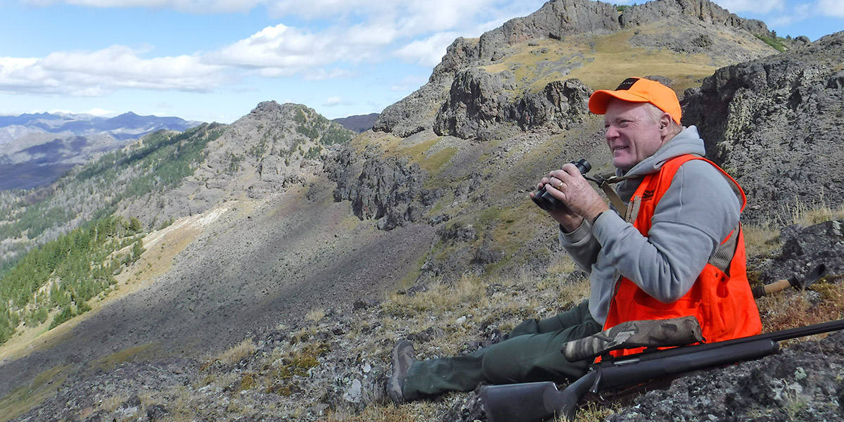 Aging hunter sitting on the side of a steep mountain Aging hunter sitting on the side of a steep mountain