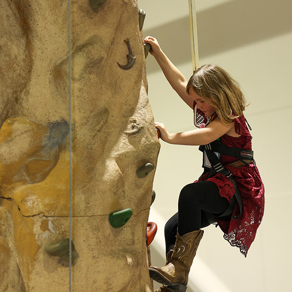 Youth attendees climbing indoors at the 2024 YWCE event Youth attendees climbing indoors at the 2024 YWCE event