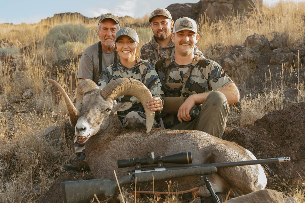 Successful woman hunter in the field with a bighorn sheep. Successful woman hunter in the field with a bighorn sheep.