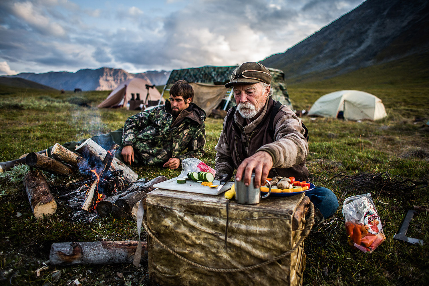 Hunter and guides preparing a meal at sheep camp by Stephen Cunic