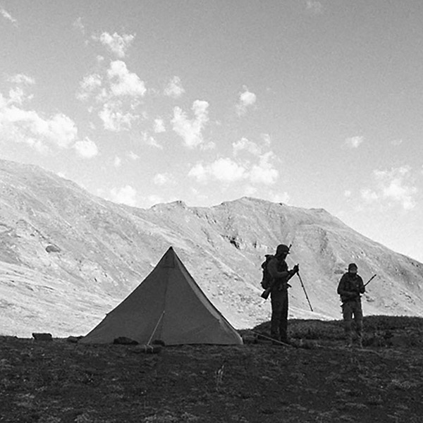 Silhouette of hunters by their tents