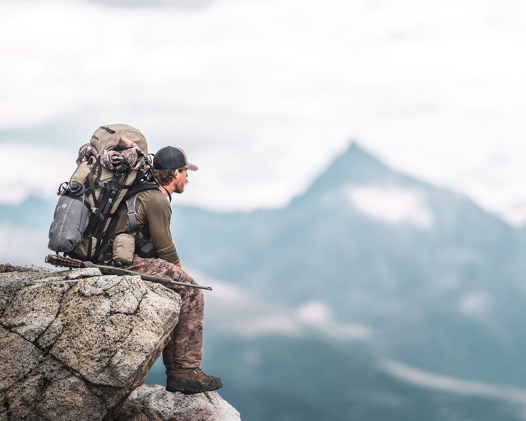 Hunter sitting on a rock outcropping - Stephen Laughter