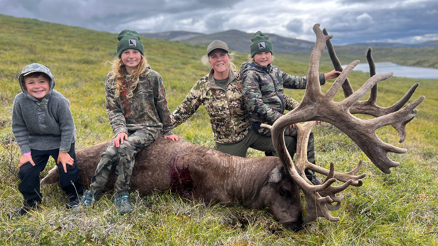 woman with caribou and children in the field