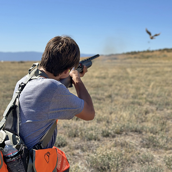 Youth hunting chukars with blue sky