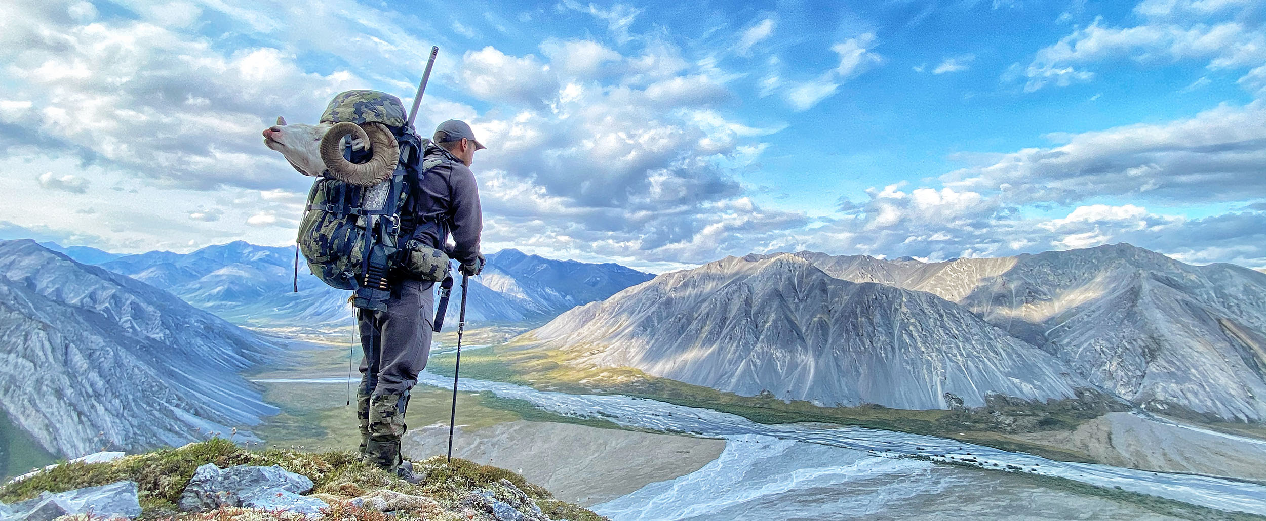 Hunter packing out a Dall's sheep by Donald Tarasiewicz
